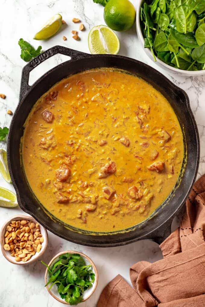 A curry sauce being cooked in a cast iron pan.