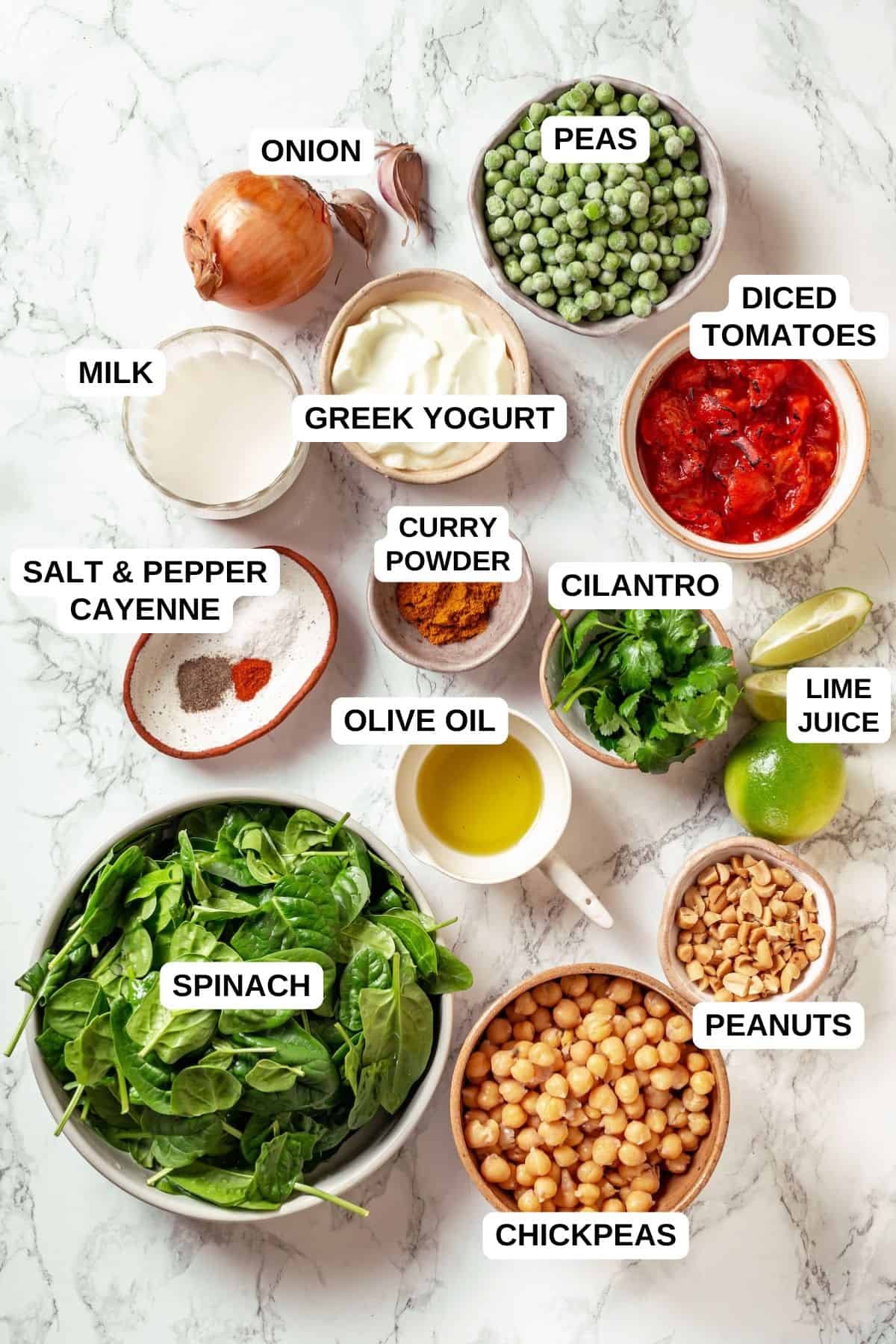Ingredients laid out in separate containers for making a vegetarian curry recipe with spinach and chickpeas.