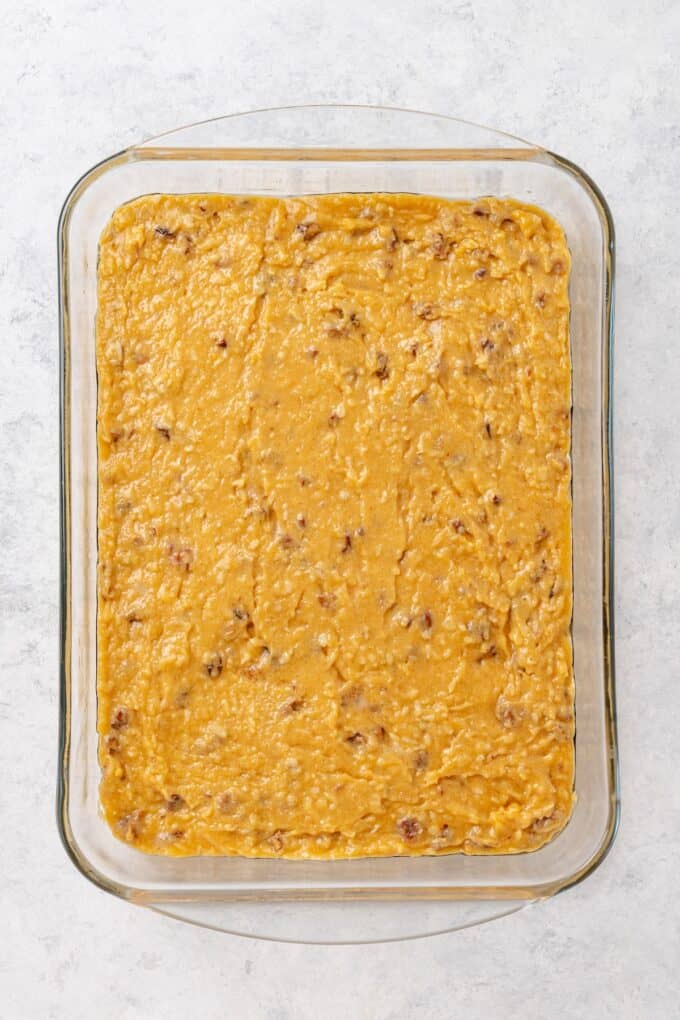 A glass casserole dish with a smooth out batter before being baked.
