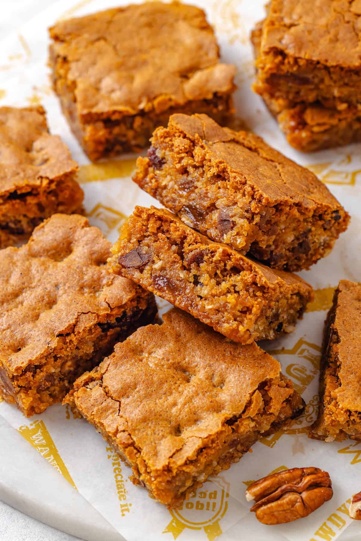 A plate full of chew bread squares with two tilted to see the thick bar shape.