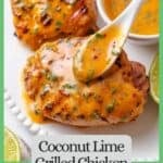 A spoon drizzling a coconut red curry lime sauce over grilled chicken on a platter with a green border and text around the photo.