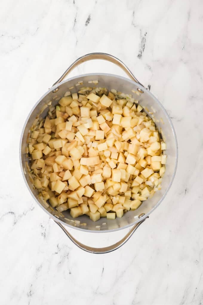 Cubed potatoes being cooked in a large pot.