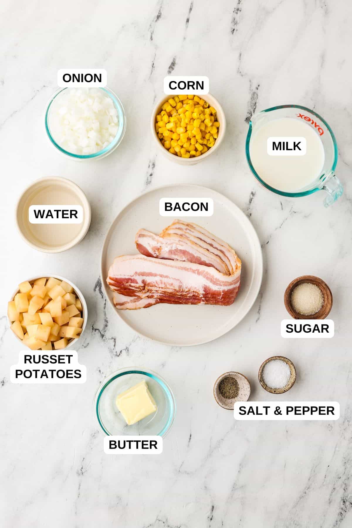 Ingredients laid out in separate bowls for making a corn chowder recipe with potatoes and bacon.