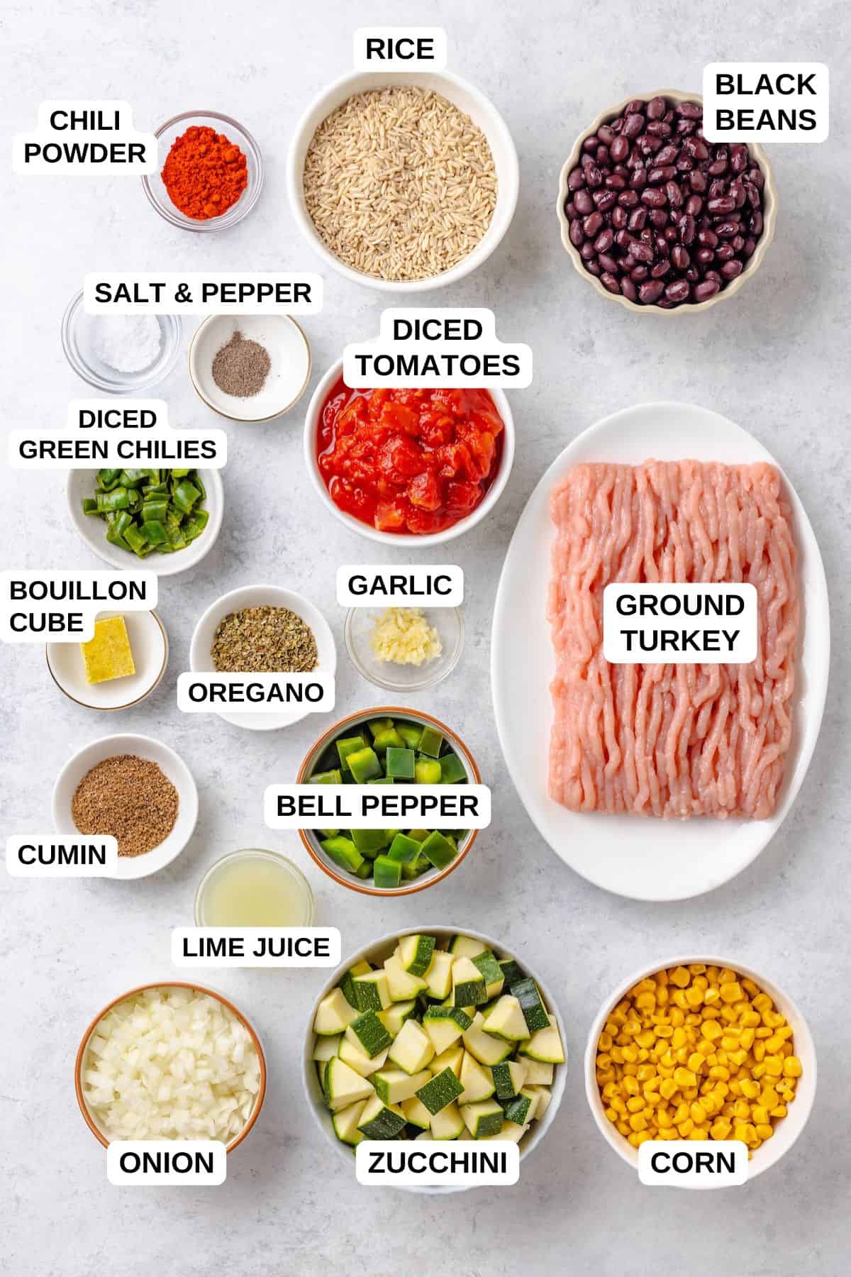 Ingredients laid out in separate bowls for making a ground turkey dish with black beans, corn, zucchini and rice.