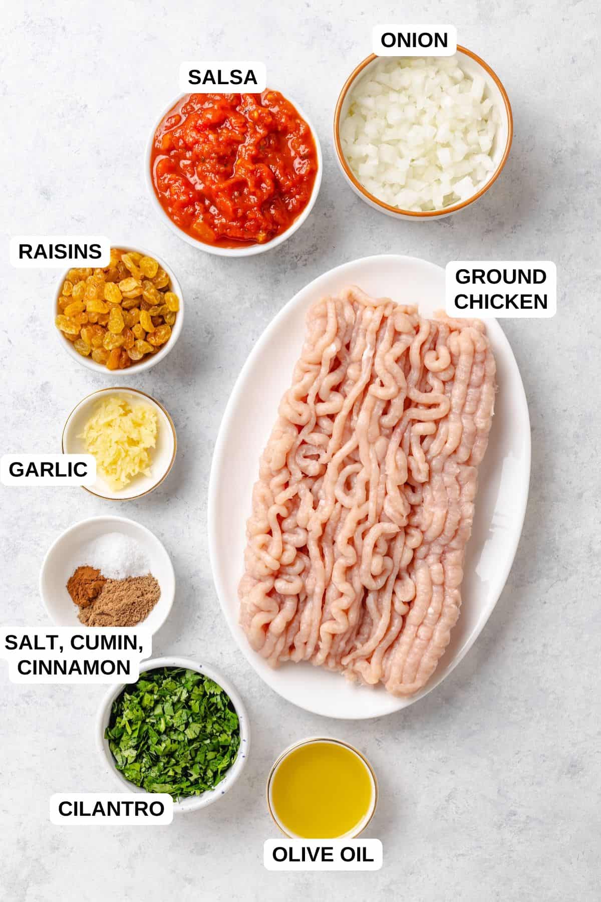 Ingredients laid out in separate containers for making a ground chicken picadillo recipe.