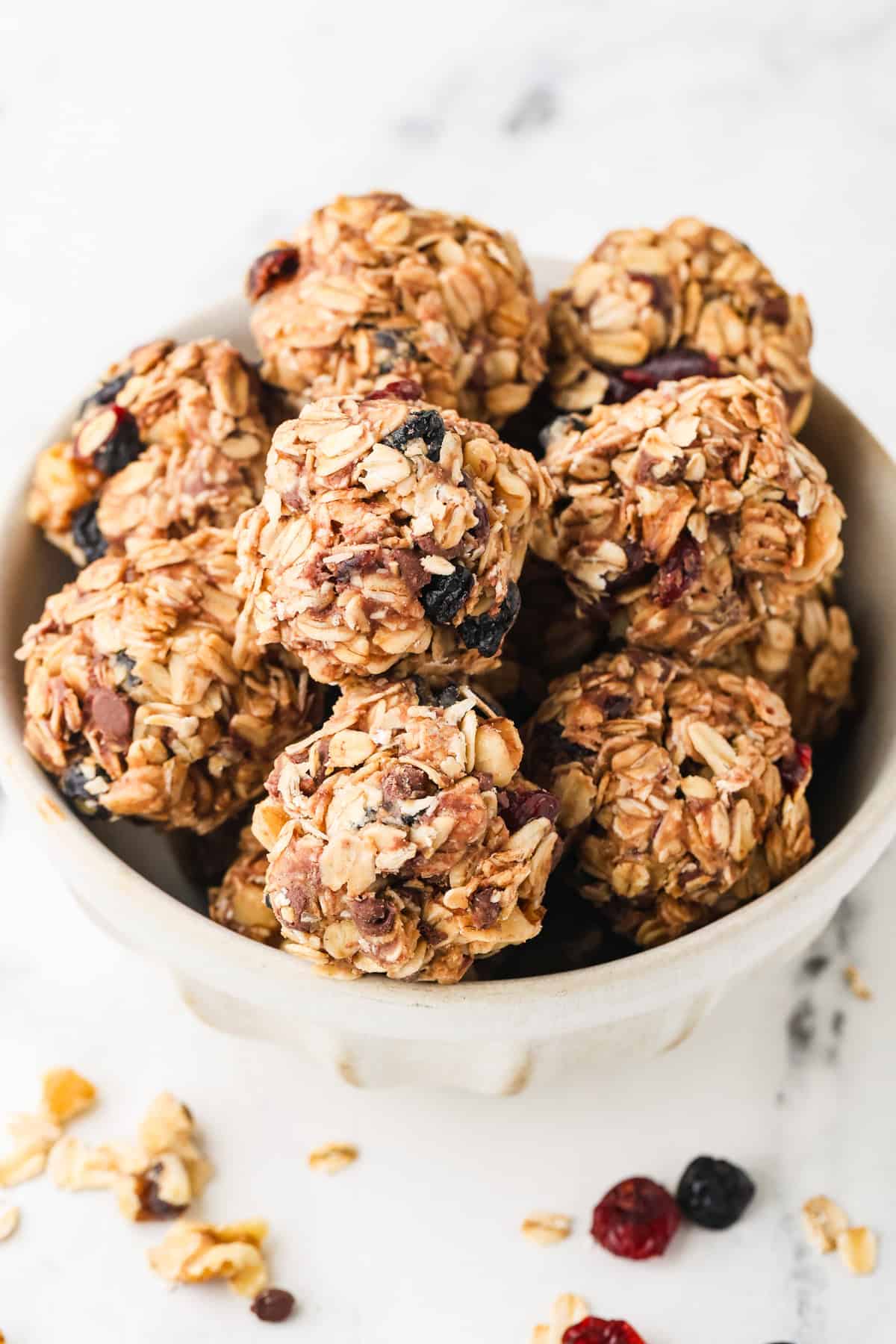 A bowl full of homemade granola bites with dried fruit and mini chocolate chips.