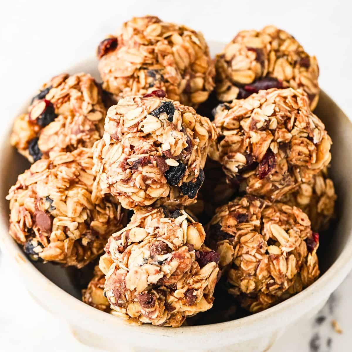 Close up of a bowl full of homemade granola bites with dried fruit and mini chocolate chips.