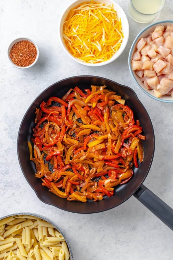 Sautéed onion and bell peppers in a cast iron skillet.