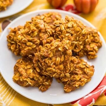 Close up of a white plate with a stack of pumpkin banana oatmeal cookies.