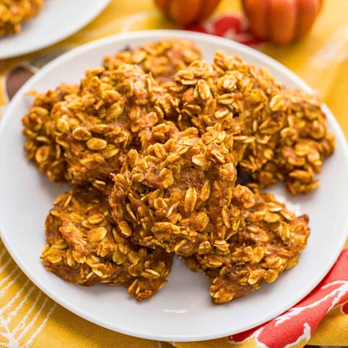 Close up of a white plate with a stack of pumpkin banana oatmeal cookies.