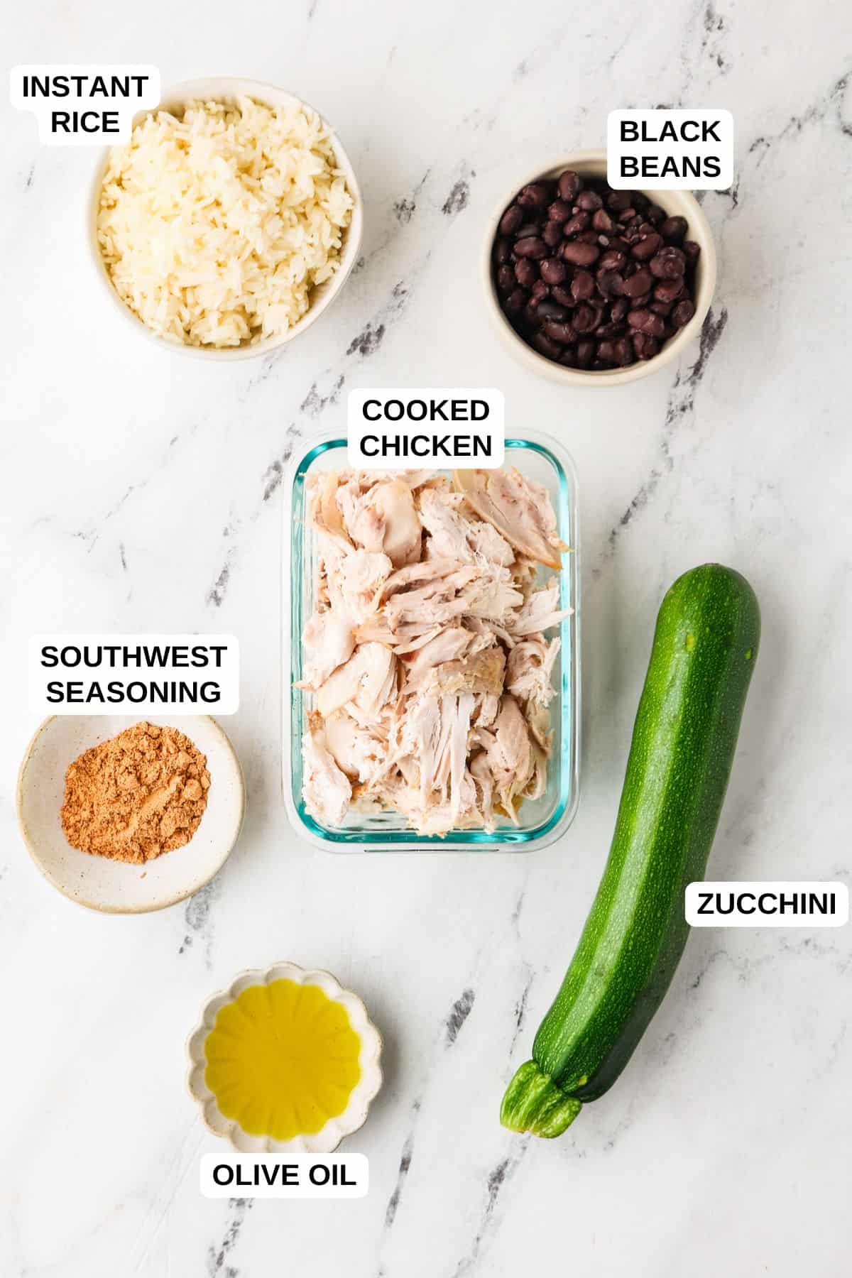 Ingredients laid out in separate containers for making a chicken and rice recipe with black beans and zucchini.