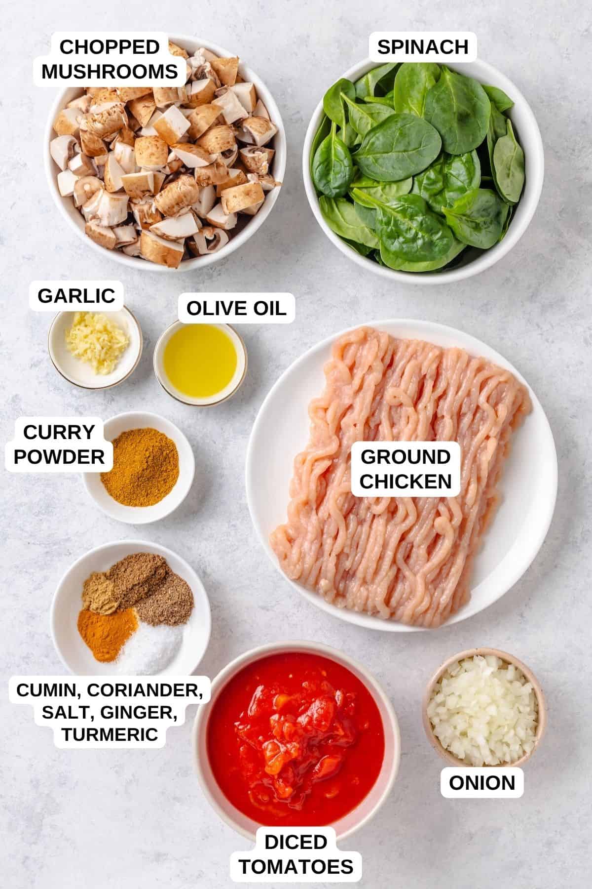 Ingredients laid out in separate containers for making a ground chicken recipe with spinach, mushrooms, tomatoes and spices.