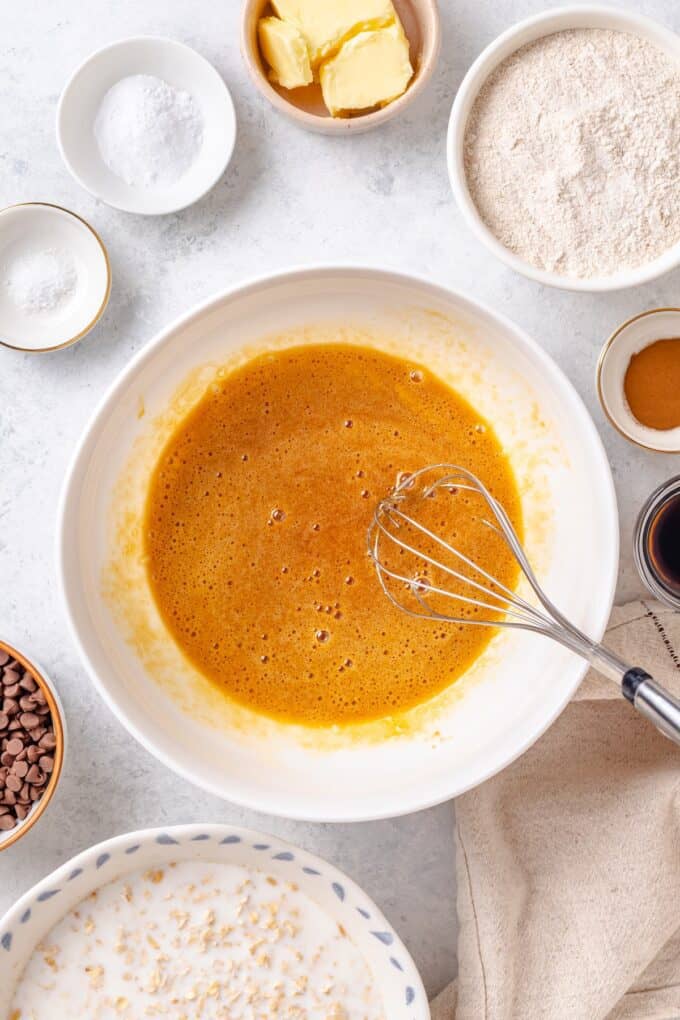 Egg and brown sugar being whisked together in a white bowl.