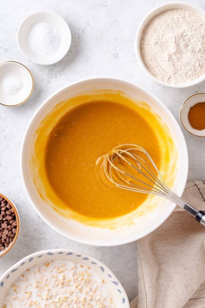 A white bowl with a butter, egg and brown sugar mixture whisked together.