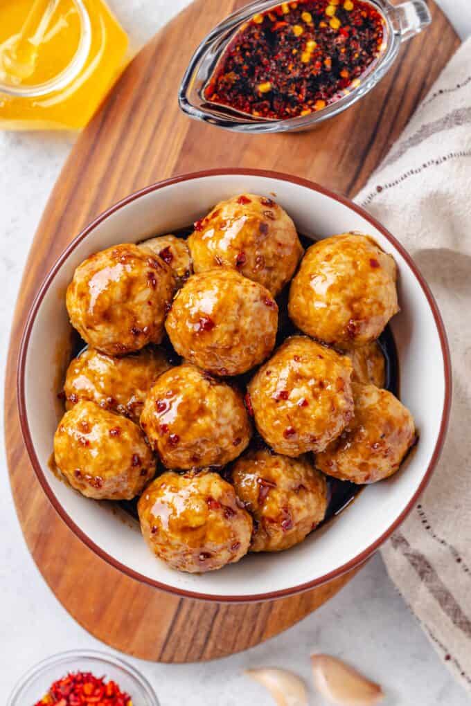 Baked honey garlic meatballs in a bowl with a sauce glaze over them.