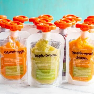 Close up of rows of homemade baby food pouches lined up and labeled with what the puree is.