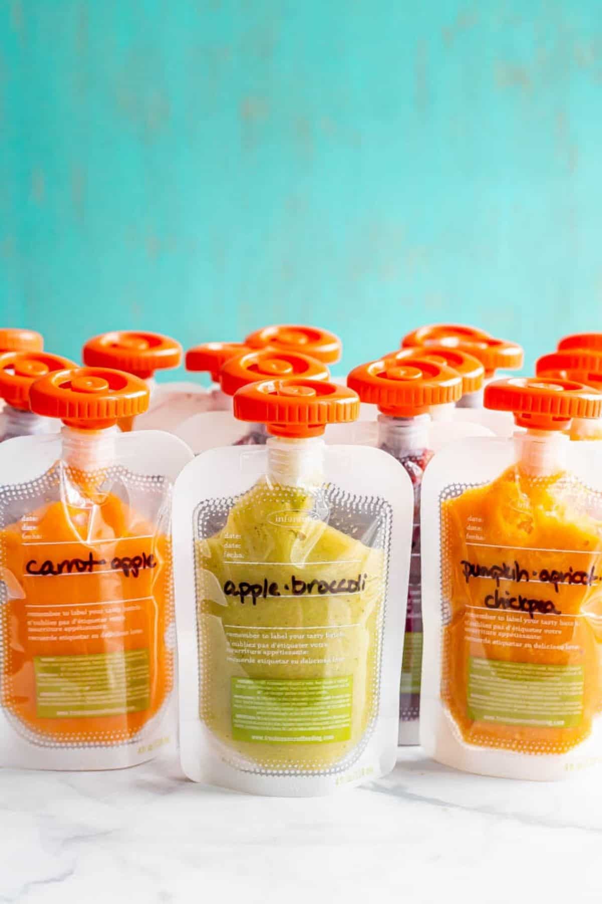 Rows of homemade baby food pouches lined up and labeled with what the puree is.