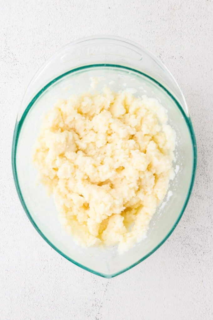 A glass container with creamy mashed potatoes.