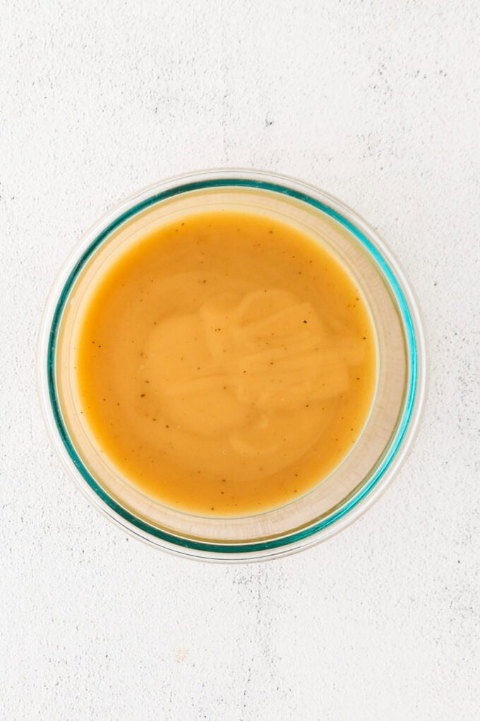 A glass bowl with gravy.