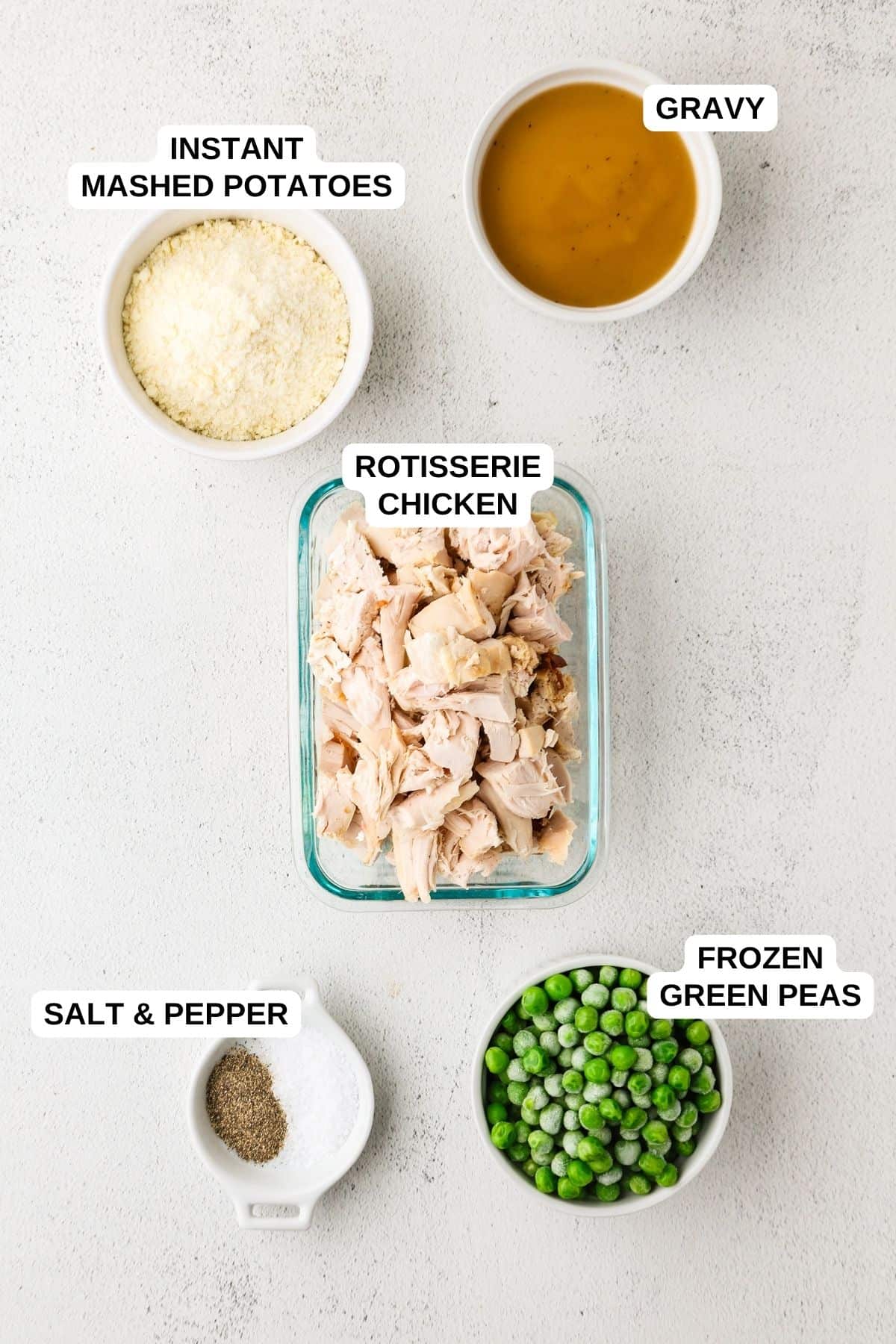 Ingredients laid out in separate containers for making a chicken, mashed potato and pea recipe with gravy.