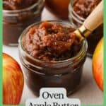 A spoon scooping up some apple butter from a small glass jar with a green border and text around the photo.